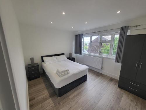 1 dormitorio con cama blanca y ventana en Bright Modern 3 Bedroom Apartment, en Sutton