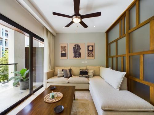 a living room with a couch and a ceiling fan at IPANA Luxury Apartments by Vacaciones.Yeah in Playa del Carmen