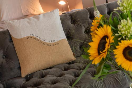 a piece of paper sitting on a couch with sunflowers at Landelijke boerderijkamer, dichtbij Kinderdijk in Oud-Alblas