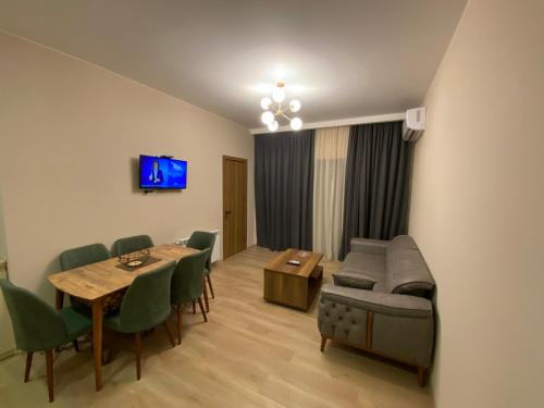 Dani Apartment في كوتايسي: غرفة معيشة مع طاولة وأريكة وكراسي