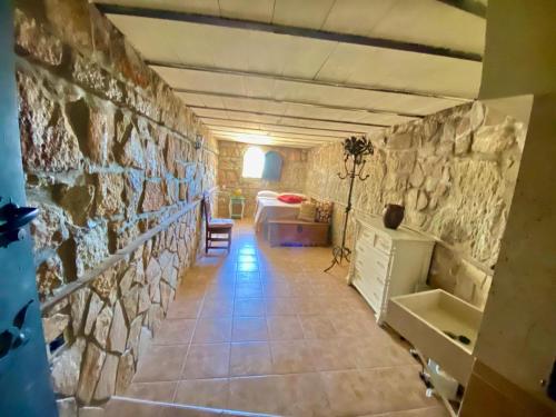 Habitación con pared de piedra y habitación con sofá en Magnífico Castillo privado, elevado en la roca en La Cabrera