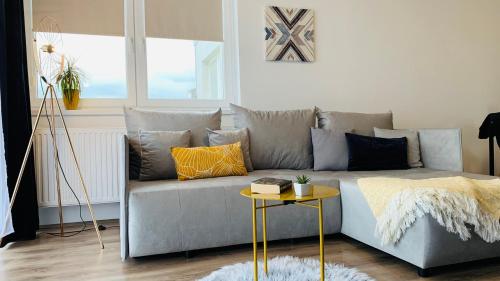 a living room with a gray couch and a table at Classy Villány in Villány