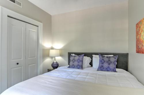 Dormitorio blanco con cama con almohadas azules en Historic King James Unit 4, en Asheville