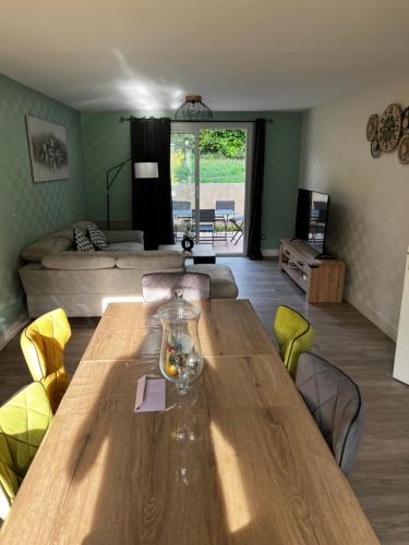 un salon avec une table en bois et un canapé dans l'établissement Belle maison familiale proche du lac, à Bourges