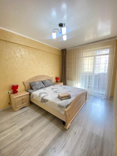 a bedroom with a large bed and a window at RentNow Family Large Apartament near Airport in Chişinău