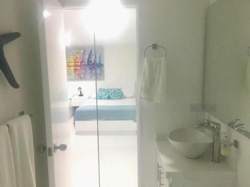 ein Bad mit einer Dusche, einem Waschbecken und einem Bett in der Unterkunft Villa del mar apartaestudio in San Andrés
