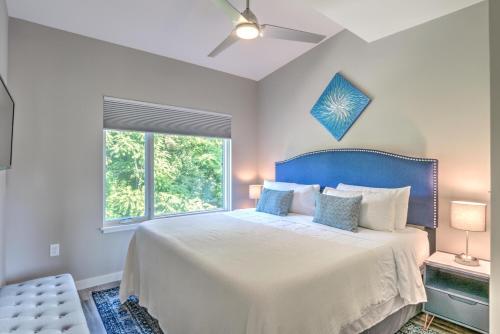 a bedroom with a bed with a blue headboard and a window at South Slope Townhome with Private Elevator Unit 102 in Asheville