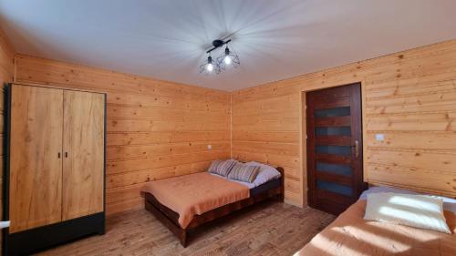 1 dormitorio con 1 cama y ventilador de techo en Domek gdzieś na końcu świata, en Bandrów Narodowy