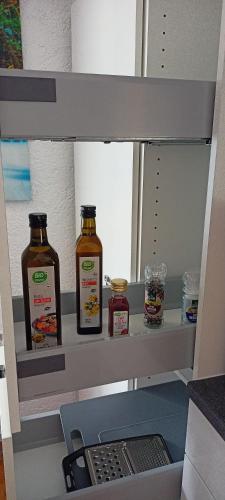 a shelf with two bottles of honey and a laptop at FeWo Blaue Oase, Netflix, Massagesessel, Whirlpool Badewanne in Germersheim