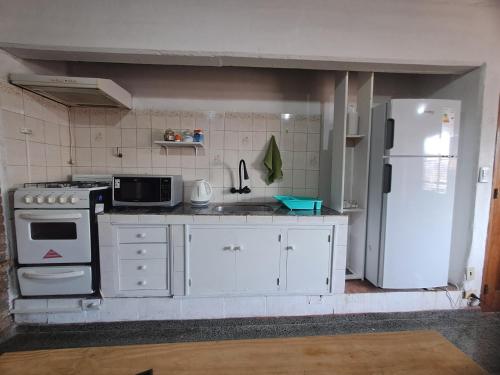 a kitchen with white appliances and a white refrigerator at Mendoza Urbano Confort in Mendoza
