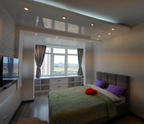 a bedroom with a bed with purple pillows and a window at Pearl KadoRR in Liski
