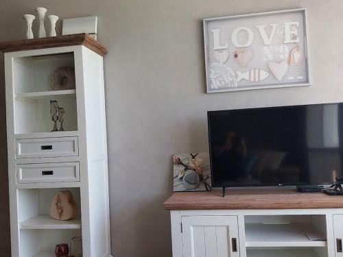 a living room with a tv and a entertainment center at Lovely n° 9 op ieder moment een prachtig zeezicht & zwembad in Middelkerke