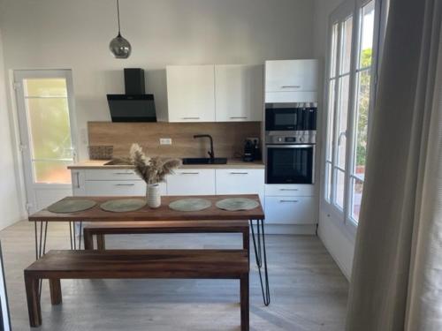 une cuisine avec une table en bois et une table sidx sidx sidx sidx dans l'établissement Villa de charme ESMEE - Plein centre, à Cavalaire-sur-Mer