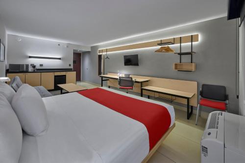a hotel room with a large bed and a kitchen at City Express by Marriott Los Mochis in Los Mochis
