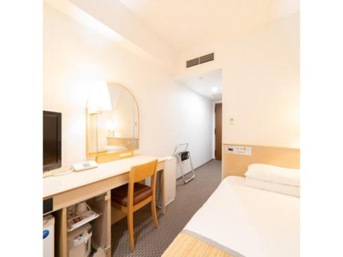 Zimmer mit einem Schreibtisch, einem Bett und einem Spiegel in der Unterkunft Hotel Terrace The Square Hitachi - Vacation STAY 17018v in Hitachi