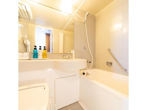 ein weißes Badezimmer mit einer Badewanne und einem Waschbecken in der Unterkunft Hotel Terrace The Square Hitachi - Vacation STAY 17018v in Hitachi