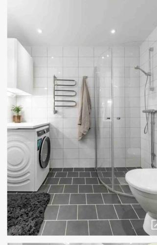 a bathroom with a shower and a washing machine at Central apartment Uppsala in Uppsala