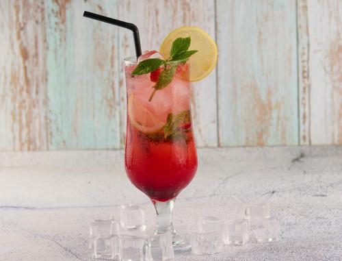 a red drink in a glass with a lemon slice at فندق سنبات بلاتينيوم in Jazan