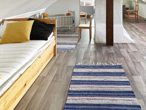 una camera con un letto e un tappeto su un pavimento in legno di Holiday home AXVALL IV ad Axvall