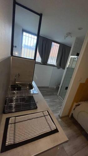 uma cozinha com um lavatório e um espelho num quarto em Logement 2 personnes. em Vitry-le-François