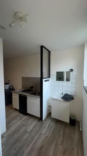 uma cozinha com frigorífico e piso em madeira em Logement 2 personnes. em Vitry-le-François