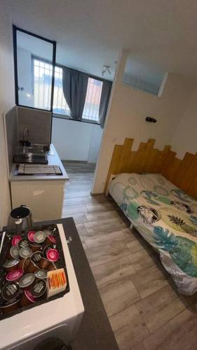 een kleine kamer met een bed en een tafel met eten bij Logement 2 personnes. in Vitry-le-François