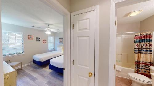 a small bedroom with a bed and a bathroom at Scenic Serenity 2BR Villa with Private Balconies in Pawleys Island