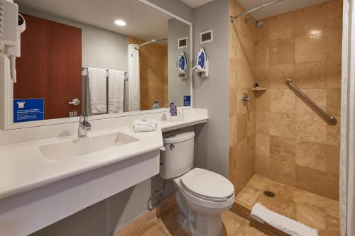 een badkamer met een toilet, een wastafel en een douche bij City Express by Marriott Puebla Centro in Puebla