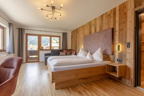 バーワングにあるAppartements SonnAlmのベッドと椅子のあるホテルの部屋