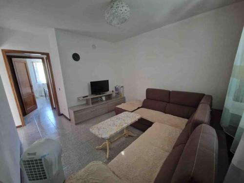 een woonkamer met een bank en een tv bij Appartamento Ciciano vista Colline Metallifere in Ciciano