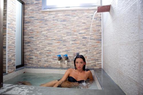 阿爾卡莫的住宿－Terme Gorga Hotel，坐在带淋浴的浴缸中的女人