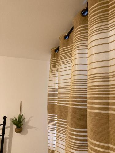 ajar curtains in a room with a plant on the wall at Chessington Home Stay , 3 Bed 6 Guests Free Parking Near M25 JCT9, Chessington world of Adv Resort, Kingston, Epsom, Great for Families & Groups in Chessington