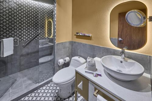 W łazience znajduje się umywalka, toaleta i lustro. w obiekcie City Centro by Marriott San Luis Potosi w mieście San Luis Potosí