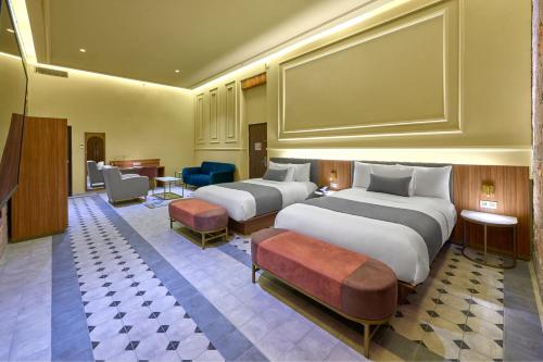 Cette chambre comprend 2 lits et une table. dans l'établissement City Centro by Marriott San Luis Potosi, à San Luis Potosí