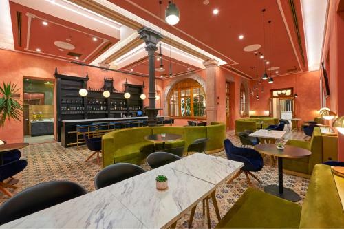 a restaurant with tables and chairs and a bar at City Centro by Marriott San Luis Potosi in San Luis Potosí