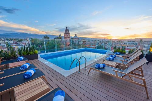 a rooftop pool with a view of a city at City Centro by Marriott San Luis Potosi in San Luis Potosí
