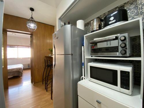 a kitchen with a microwave and a refrigerator at Obelisco Studio 9 in Buenos Aires