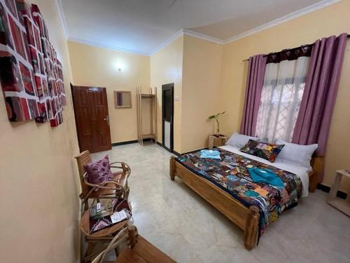 a bedroom with a bed and a chair in it at Home Feeling Kilimanjaro in Moshi