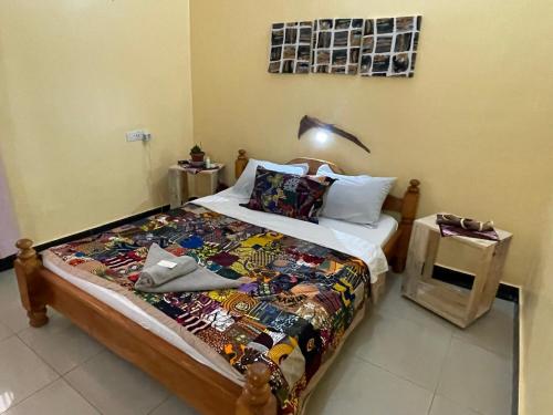 a bedroom with a bed with a quilt on it at Home Feeling Kilimanjaro in Moshi