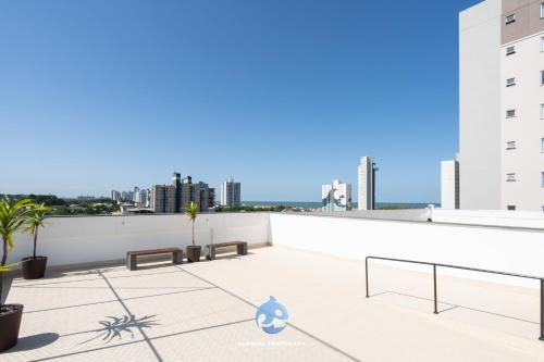 a balcony with benches and a view of the city at Apto a 150m DA PRAIA e 15min BETO CARREIRO com WI-FI, PISCINA, PORTARIA 24h, PLAYGROUND INFANTIL, QUADRA DE ESPORTES sacada com CHURRASQUEIRA e vaga de GARAGEM in Piçarras