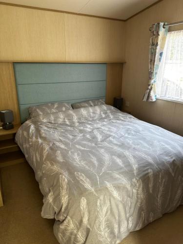 una camera da letto con un grande letto e un piumone bianco di Happy Place a West Mersea