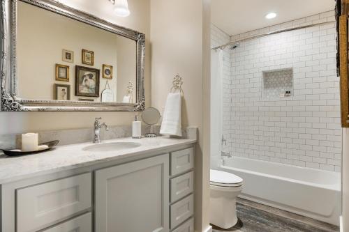 a bathroom with a sink and a toilet and a mirror at Inn at Sunset Mill Ranch in Wimberley