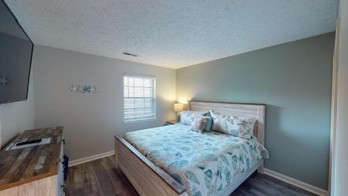 帕利斯島的住宿－Fairway Retreat 2BR Pawleys Island Golf Paradise，一间卧室配有一张带木制床头板的床和窗户。