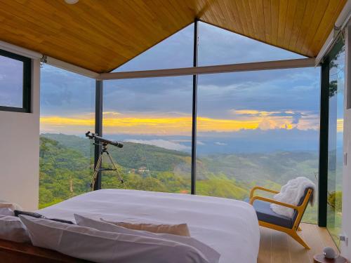 a bedroom with a large window with a camera at Amalú Monteverde in Monteverde Costa Rica