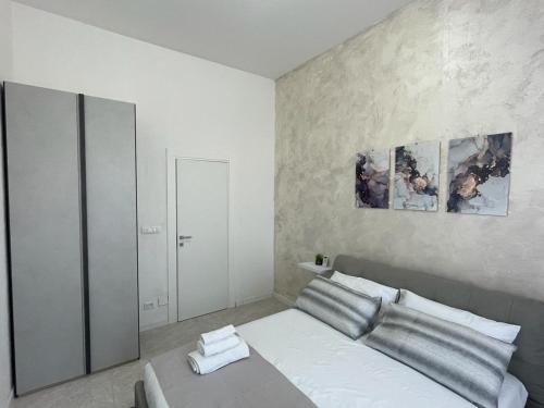een slaapkamer met een bed met twee schilderijen aan de muur bij Residenza del Borgo in Siracusa