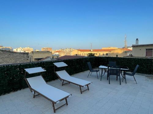 een patio met stoelen en tafels op een dak bij Residenza del Borgo in Siracusa