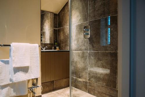 uma casa de banho com um chuveiro e uma porta de vidro em The Assheton Arms em Clitheroe