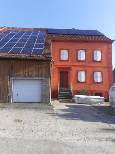 une maison avec beaucoup de panneaux solaires sur le toit dans l'établissement bel appartement de 56 m² au calme et de plein pied, à Bust