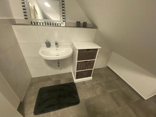 a white bathroom with a sink and a mirror at Colmdorf 14a Ferienhaus in Bayreuth