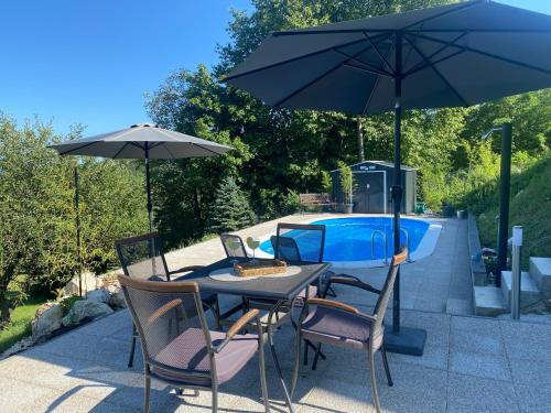 un tavolo e sedie con ombrellone accanto a una piscina di Relax House Lara in Krapinske Toplice a Krapinske Toplice